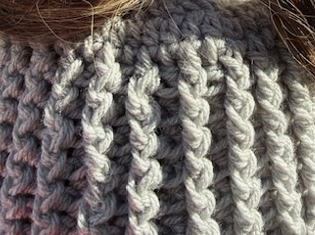 Close up of Silver Passage open-tail messy bun ribbed crochet beanie showing winter stitch detail
