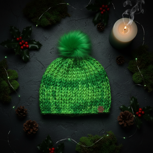Emerald Pulse crochet beanie in vibrant green yarn with matching faux fur pom styled in moody still life composition designed for cold climate winter warmth