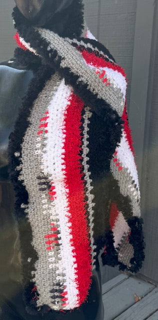Eye of the Storm classic rib crochet beanie with pom styled with matching scarf in cold-weather stadium setting - coordinate